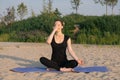 Beautiful woman practising yoga in a city park