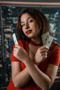 Beautiful Caucasian woman in red dress with poker cards gambling in casino posing and smiling Royalty Free Stock Photo