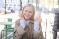 Beautiful caucasian woman, sitting in outdoor cafe with cup of coffee, drinking cappuccino, smiling and looking happy Royalty Free Stock Photo