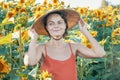 Beautiful Caucasian woman in sunflowers, portrait of a woman wearing a Vietnamese hat walking through a blooming field Royalty Free Stock Photo