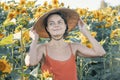 Beautiful Caucasian woman in sunflowers, portrait of a woman wearing a Vietnamese hat walking through a blooming field Royalty Free Stock Photo