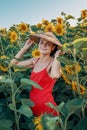 Beautiful Caucasian woman in sunflowers, portrait of a woman wearing a Vietnamese hat walking through a blooming field Royalty Free Stock Photo