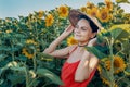 Beautiful Caucasian woman in sunflowers, portrait of a woman wearing a Vietnamese hat walking through a blooming field Royalty Free Stock Photo