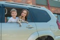 Beautiful caucasian woman travels with a child and a dog. Mom and son leaned out of the car window in an embrace with a Royalty Free Stock Photo