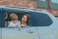 Beautiful caucasian woman travels with a child and a dog. Mom and son leaned out of the car window in an embrace with a Royalty Free Stock Photo