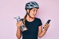 Beautiful caucasian woman wearing bike helmet looking at smartphone celebrating crazy and amazed for success with open eyes Royalty Free Stock Photo