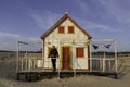 Beautiful caucasian woman wearing a black leather jacket under the porch of a typical abandoned house on the beach at Costa da Royalty Free Stock Photo