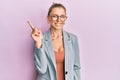 Beautiful caucasian woman wearing business jacket and glasses showing and pointing up with finger number one while smiling Royalty Free Stock Photo