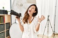 Beautiful caucasian woman working as photographer at photography studio crazy and mad shouting and yelling with aggressive Royalty Free Stock Photo