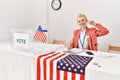 Beautiful caucasian woman working at political campaign smiling pointing to head with one finger, great idea or thought, good