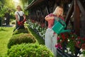 Woman watering flowers while man cutting bushes at garden Royalty Free Stock Photo