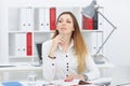 Beautiful Caucasian young busines woman is looking into the distance, sitting at her workplace. Royalty Free Stock Photo