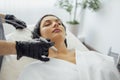 Beautiful caucasian young woman is doing a mole removal procedure in a modern beauty cosmetic dermatological clinic