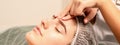 Beautiful caucasian young woman receiving a facial massage with closed eyes in spa salon, close up. Relaxing treatment Royalty Free Stock Photo