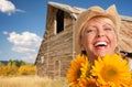 Beautiful Caucasian Young Woman Wearing Cowboy Hat Holding Sunflower In Front of Rustic Barn In The Country Royalty Free Stock Photo