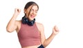 Beautiful caucasian young woman wearing gym clothes and using headphones dancing happy and cheerful, smiling moving casual and Royalty Free Stock Photo