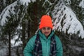 A beautiful caucasian young woman in a winter wonderland enjoying the snow fashion photoshoot wearing colourful jacket and red cap Royalty Free Stock Photo