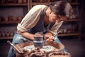 Charming handicraftsman creates a new pottery from clay on a potter`s wheel. Pottery workshop. Royalty Free Stock Photo