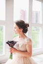 Beautiful charming bride in a luxurious dress looking up.Portrait Of Happy Bride Sitting in wedding dress in a Studio. Young attra