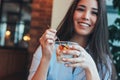 Beautiful charming brunette smiling Asian girl has Breakfast with coffee and Chia pudding at cafe