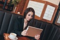 Beautiful charming brunette smiling Asian girl with tablet at table in cafe, student, freelancer or young manager Royalty Free Stock Photo