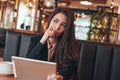 Beautiful charming brunette worried asian girl with tablet at table in cafe, student, freelancer or young manager Royalty Free Stock Photo