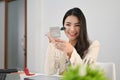 Beautiful Asian businesswoman looking at the mirror and applying makeup on her face Royalty Free Stock Photo