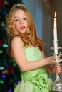 Beautiful charming pretty blond child-girl on the background of a New Year tree Royalty Free Stock Photo