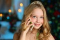 Beautiful charming pretty blond child-girl on the background of a New Year tree