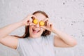 Beautiful charming redhead smiling happy teenager girl closing her eyes by macarons isolated on white brick wall Royalty Free Stock Photo