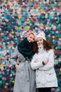 Beautiful charming smiling young teenage girls two sisters having fun posing against a colorful bright wall Royalty Free Stock Photo