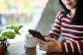 Beautiful Asian woman using her smartphone while relaxing in the coffee shop. cropped image Royalty Free Stock Photo