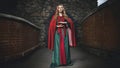 Beautiful charming young blonde girl in the medieval green dress with a cape Royalty Free Stock Photo