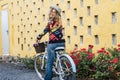 Beautiful and cheerful active young adult caucasian woman ready to go on bike bycicle ride activity at home in the garden - pretty