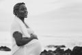 Beautiful cheerful african american pregnant woman holding her belly, smiling, looking with hope to the future. Real people Royalty Free Stock Photo