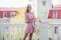 beautiful cheerful blonde in a pink dress and hat in her hands walk on the street in the park Royalty Free Stock Photo