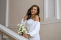 Beautiful cheerful bride in a white wedding dress holding a bouquet of white flowers Royalty Free Stock Photo