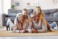 Beautiful cheerful family two cute little kids hugging with positive senior grandparents on floor