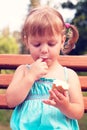 Beautiful cheerful girl eats ice cream and sucking a finger on t Royalty Free Stock Photo
