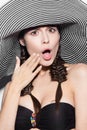 Beautiful cheerful girl in a summer beach striped hat. The beauty of the face. Royalty Free Stock Photo