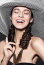Beautiful cheerful girl in a summer beach striped hat. The beauty of the face. Royalty Free Stock Photo