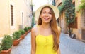 Beautiful cheerful girl in Trastevere, Rome. Happy fashion woman with yellow dress and hat walks through the streets of Rome,