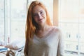 Beautiful cheerful happy young smiling redhead girl, morning sunrise light, waking up early