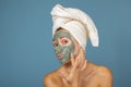 Beautiful cheerful teen girl applying facial clay mask. Beauty treatments, isolated Royalty Free Stock Photo