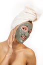 Beautiful cheerful teen girl applying facial clay mask. Beauty treatments, isolated over white Royalty Free Stock Photo