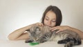 Beautiful cheerful teen girl with a cat playing with green fidget spinner on white background Royalty Free Stock Photo