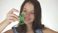 Beautiful cheerful teen girl playing with green fidget spinner on white background Royalty Free Stock Photo