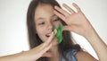 Beautiful cheerful teen girl playing with green fidget spinner on white background