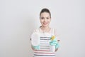 Beautiful cheerful woman holding different cleaning stuff. Isolated