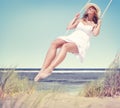 Beautiful Cheerful Woman Swinging by the Beach